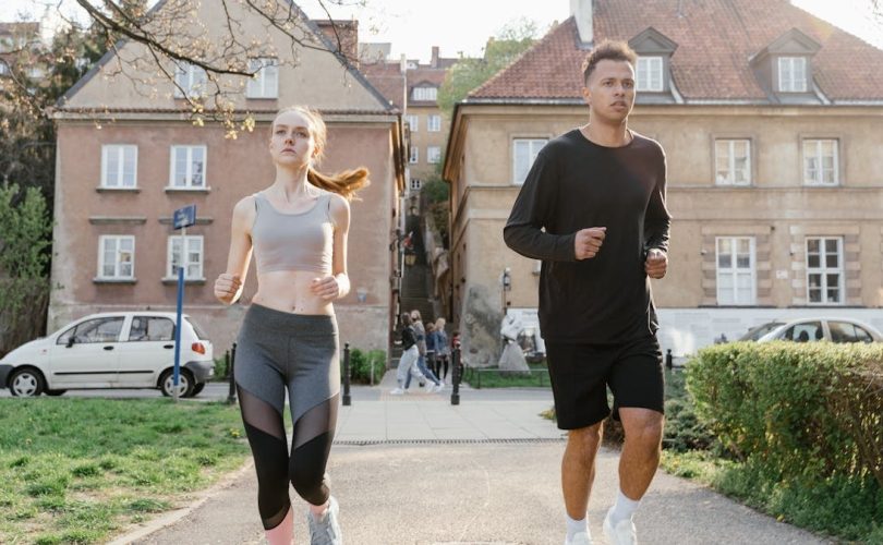 Two young adults jogging on a city path, showcasing an active lifestyle in an urban environment.